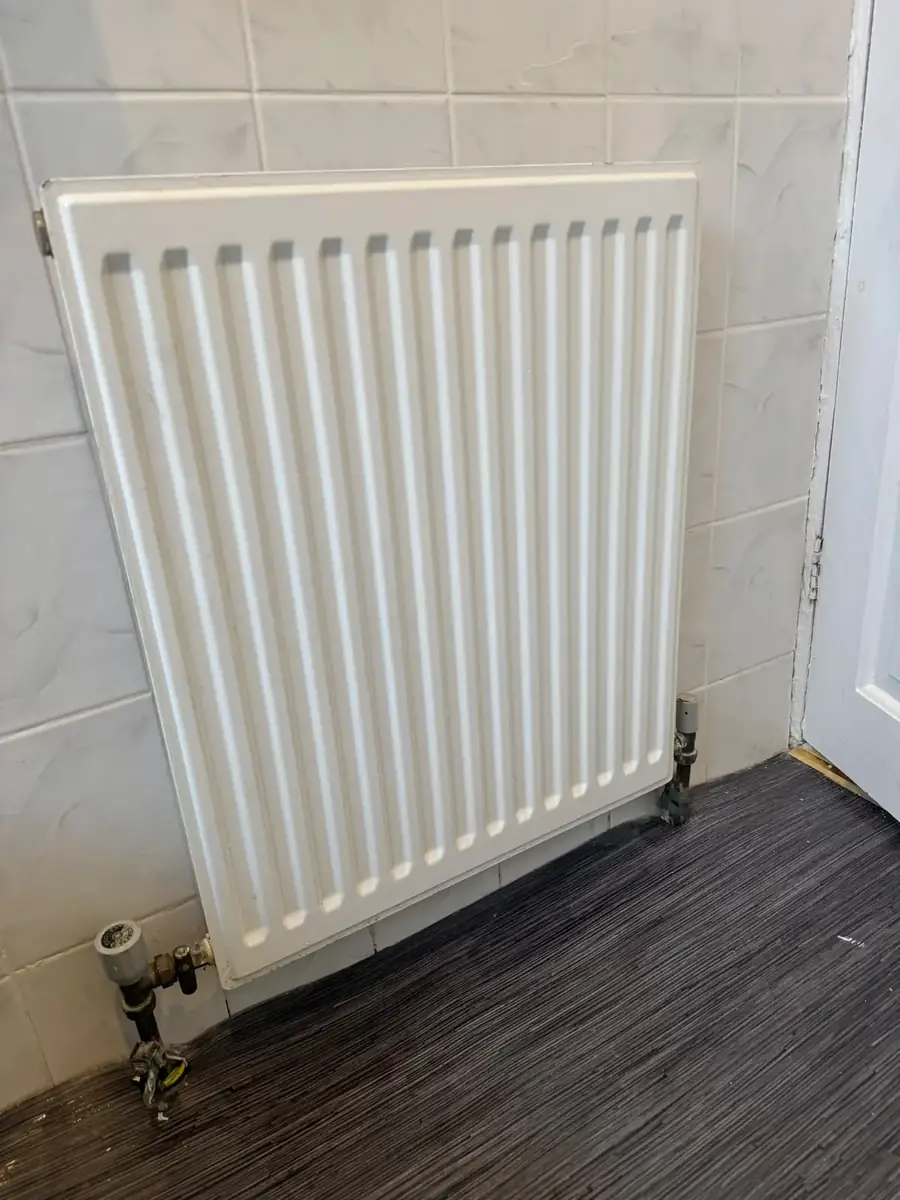 Fitted white panel radiator and valves